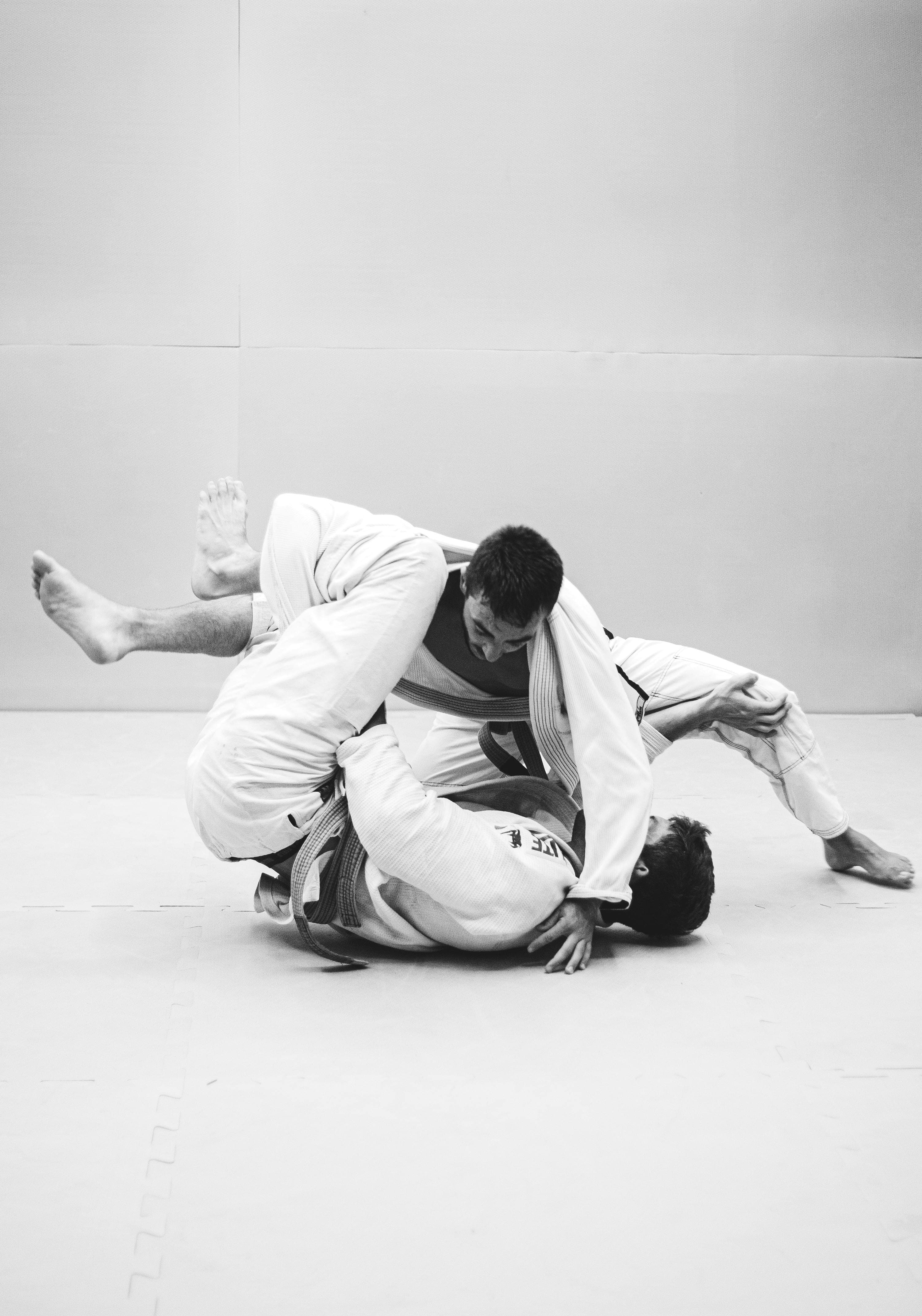 Two people rolling in a Brazilian Jiu Jitsu gym